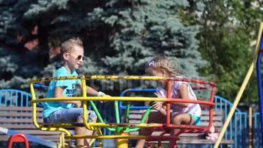 快乐的孩子们，一个女孩和一个七岁的男孩，骑在秋千上，在<strong>炎热</strong>的<strong>夏天</strong>。 慢动作。 快乐的童年